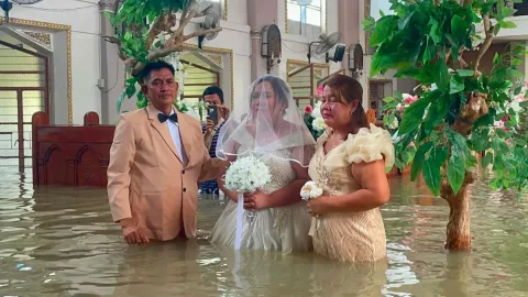Di Tengah Banjir Setinggi Pinggang, Sepasang Kekasih di Filipina Tetap Melangkah ke Pelaminan
